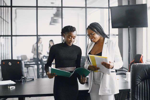 Collaboratrices d'INTROP AFRICA VM consultant un dossier au bureau